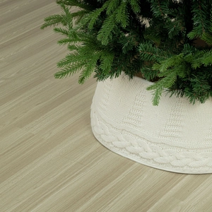 Détail du cache-pied de sapin de Noël en tricot blanc avec motif torsadé épais