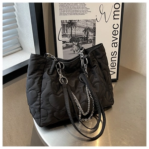 Détail du sac cabas en nylon noir avec surpiqûres cœurs et bandoulière chaîne argentée