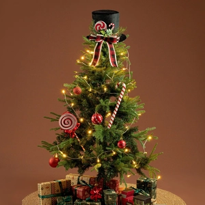 Detail of black top hat tree topper with plaid bow, red ornaments, and warm LED lights