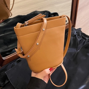 Sac seau minimaliste couleur caramel en cuir lisse avec détails de rivets argentés