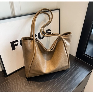 Close-up of brown tote bag with vintage pleated leather texture and durable shoulder strap