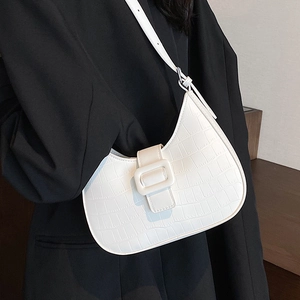 White crocodile pattern crescent hobo bag with gold buckle on a black suit model