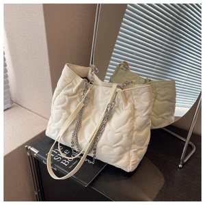 Détail du sac cabas matelassé blanc avec motif cœur et bandoulière chaîne argent