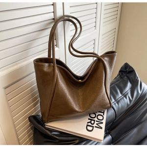 Detailed view of large dark brown tote bag with vintage texture and sleek shoulder straps