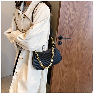 Détail d'un sac croissant noir plissé avec chaîne dorée et bandoulière en cuir