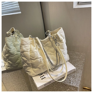 Détail d'un sac cabas blanc en nylon avec matelassage en cœur et chaîne argentée chic