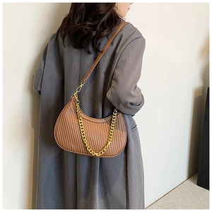 Détail d'un sac dumpling plissé marron avec chaîne dorée et bandoulière en cuir élégante