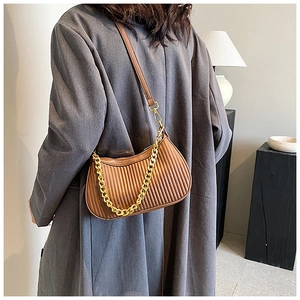 Détail du sac plissé marron caramel avec chaîne dorée et bandoulières en cuir