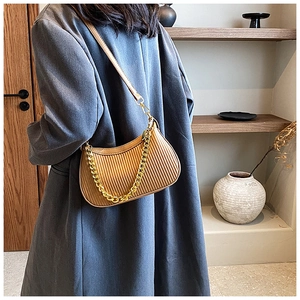 Détail du sac plissé marron foncé avec chaîne dorée et bandoulière en similicuir