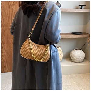 Détail du sac plissé marron avec une chaîne dorée et une bandoulière en cuir