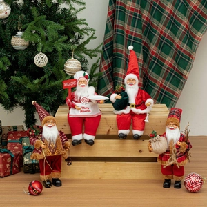 Detail of 12-inch sitting Santa dolls featuring welcome signs and Merry Christmas aprons