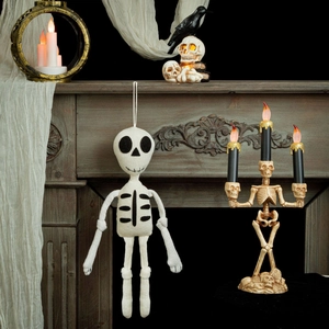 Knitted skull ornament for Halloween party decor hanging in front of a rustic fireplace