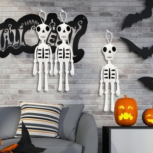 Tre bambole scheletro lavorate a maglia su una parete con decorazioni di zucca festose