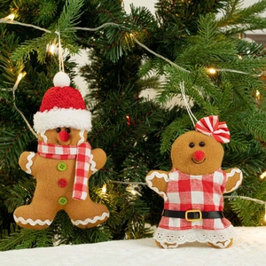 Detail van pluche kerstmis peperkoekmannetjes hangend aan een kerstboom met kerstverlichting