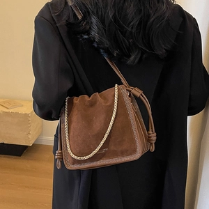 Retro brown suede bucket bag with contrast stitching and chunky gold chain strap