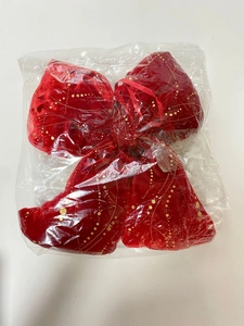 Dettaglio di fiocco natalizio in velluto rosso con glitter dorati nella confezione