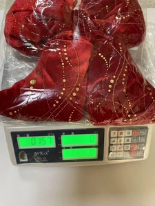 Dettaglio di un fiocco di Natale in velluto rosso con punti dorati sulla bilancia