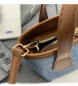 Close-up of blue crocodile pattern texture and premium golden hardware on bucket bag