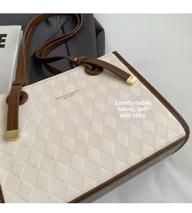 Detail of quilted faux leather tote bag showing soft fabric texture and golden logo