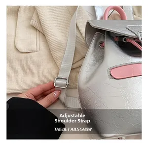 Détails des bretelles grises réglables et de la texture plissée argentée du sac à dos