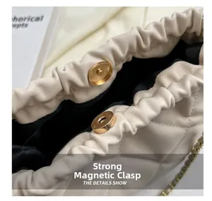 Detailed close-up of strong magnetic closure on beige quilted bucket bag with gold chain