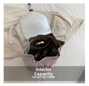 Détail de l'intérieur d'un sac à dos argenté montrant le compartiment spacieux avec cordon