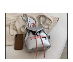 Vue de dessus d'un mini sac à dos argenté à côté d'un smartphone pour la taille