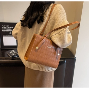 Brown quilted tote bag styled with a beige knit sweater for a casual autumn look