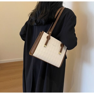 Detail of contrast stitching and woven texture on a chic white and brown tote bag