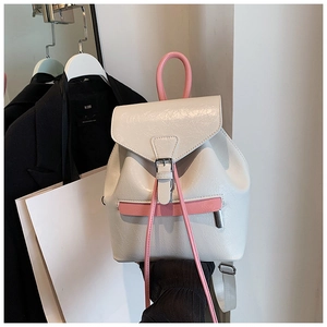 Détail du sac à dos en similicuir blanc avec poignées roses et texture plissée