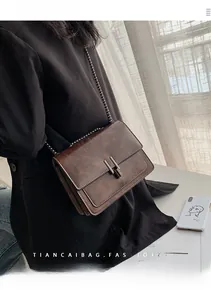 Détail du sac bandoulière vintage en cuir marron texturé avec chaîne en métal