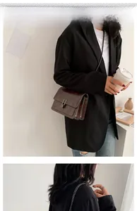 Détail du sac bandoulière vintage avec chaîne et fermoir en métal sur similicuir marron