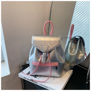 Détail d'un sac à dos argenté métallisé avec garniture rose et fermeture à cordon