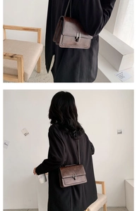 Détail d'un sac bandoulière vintage marron en cuir PU avec boucle argentée et chaîne