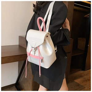 Vue latérale du sac à dos en cuir verni brillant blanc et rose porté par un mannequin