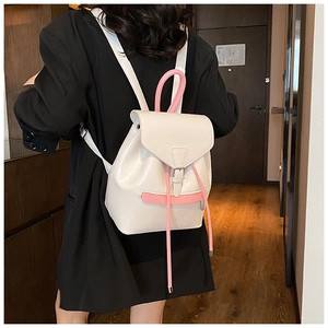 Vue détaillée du sac à dos en cuir beige et rose avec cordon porté par un mannequin