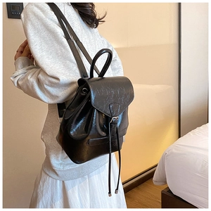 Détail du sac à dos en similicuir noir vintage avec boucle et fermeture à cordon réglable