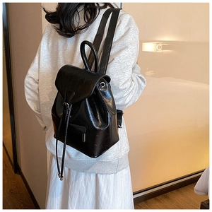 Vue latérale d'un sac à dos vintage en similicuir noir porté par un mannequin