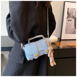 Detail of light blue crossbody bag with gold Fashion buckle and plush rabbit charm