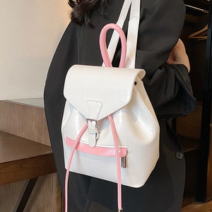 Sac à dos blanc brillant en similicuir avec poignées roses porté par un mannequin chez soi