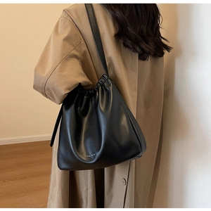 Detail der schwarzen Kordelzug-Beuteltasche mit weicher PU-Faltenoptik und Markentext