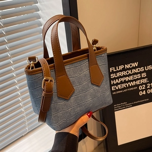 Blue crocodile pattern bucket bag with brown leather handles and golden hardware