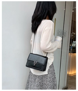 Détails du sac bandoulière en cuir noir avec coutures blanches et boucle argentée