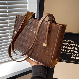 Brown quilted tote bag with dual handles and embossed leather texture for women