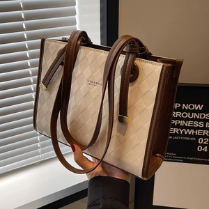 Quilted beige and brown tote bag with fashion branding and dual-tone shoulder straps