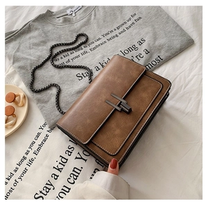 Détail d'un sac à chaîne vintage en cuir marron avec texture mate et boucle en métal
