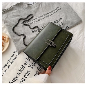 Détail du sac en cuir vert olive avec surpiqûres blanches et boucle métallique de fermeture