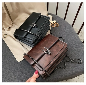 Détail de sacs bandoulière chic en noir et marron vintage avec fermoirs métalliques en forme de H