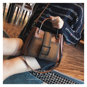 Détail d'un sac à main en cuir marron dégradé avec boucle métallique et poignée structurée
