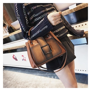 Détail d'un sac à main marron vintage avec une grande boucle métallique carrée